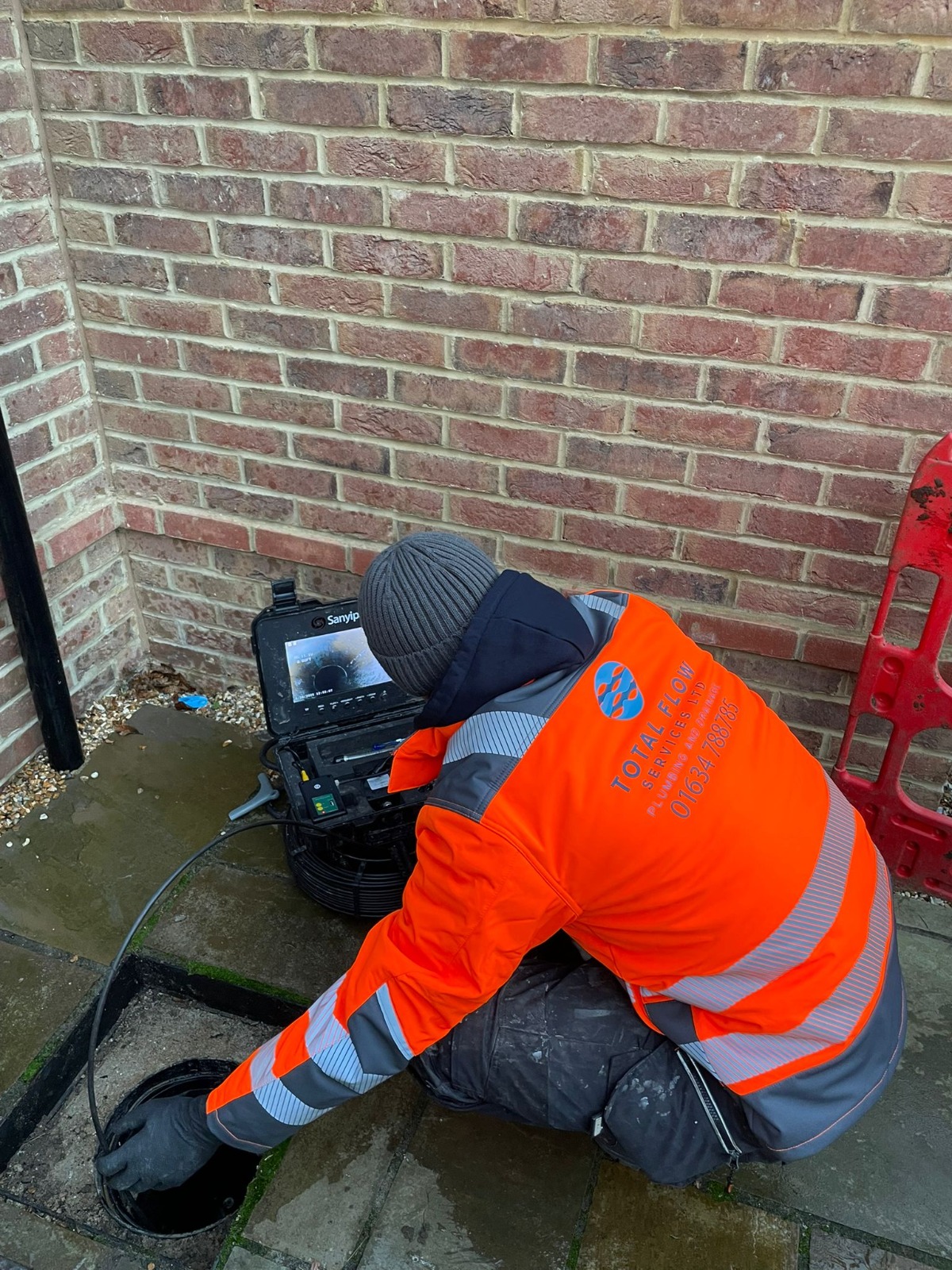 Engineer reviewing live CCTV drain survey footage on the on-site monitor