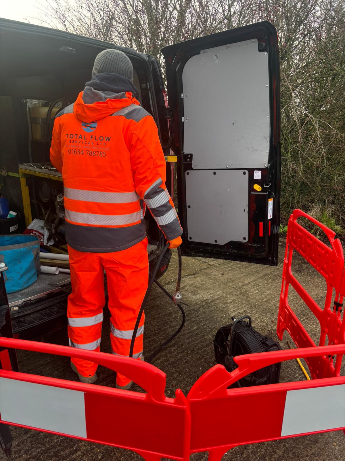 High-pressure drain jetting equipment set up from a work van